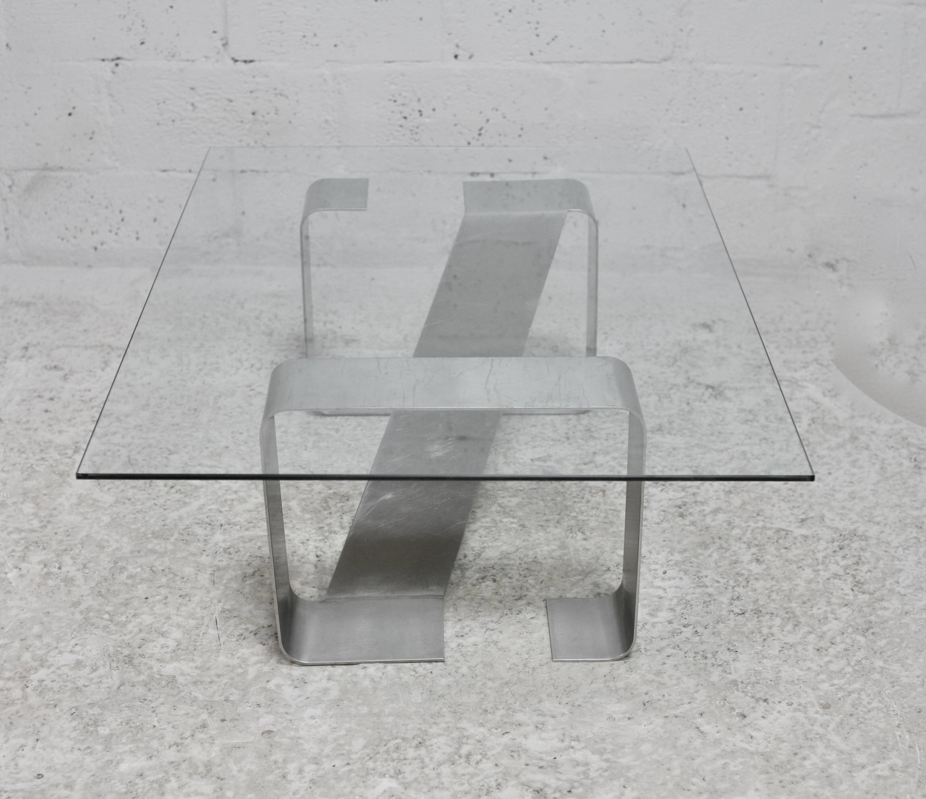 Coffee table with "kinetic" steel base and glass slab. Circa 1970.
