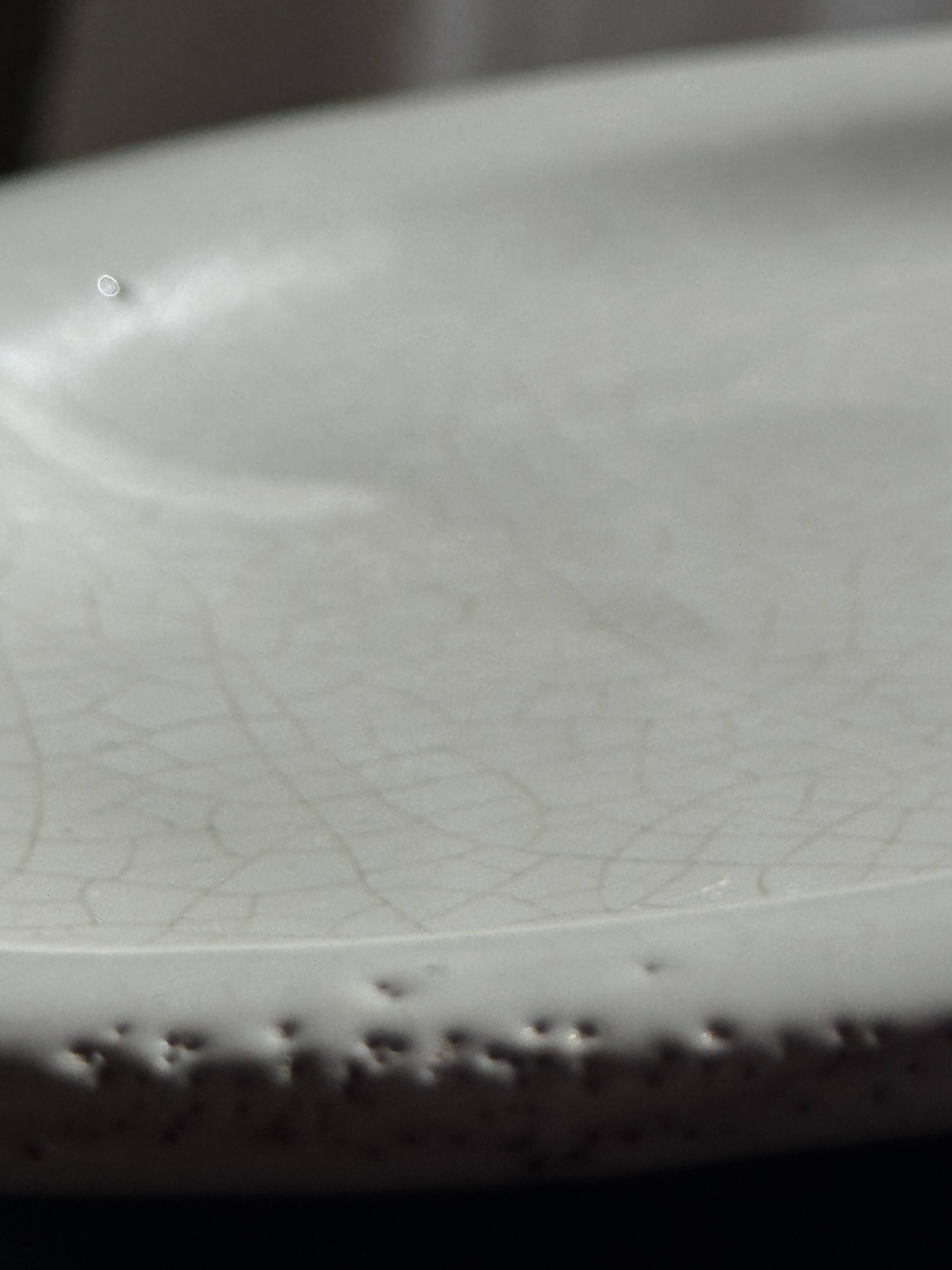 Antique oval-shaped white crackled faience plate with a scalloped edge.