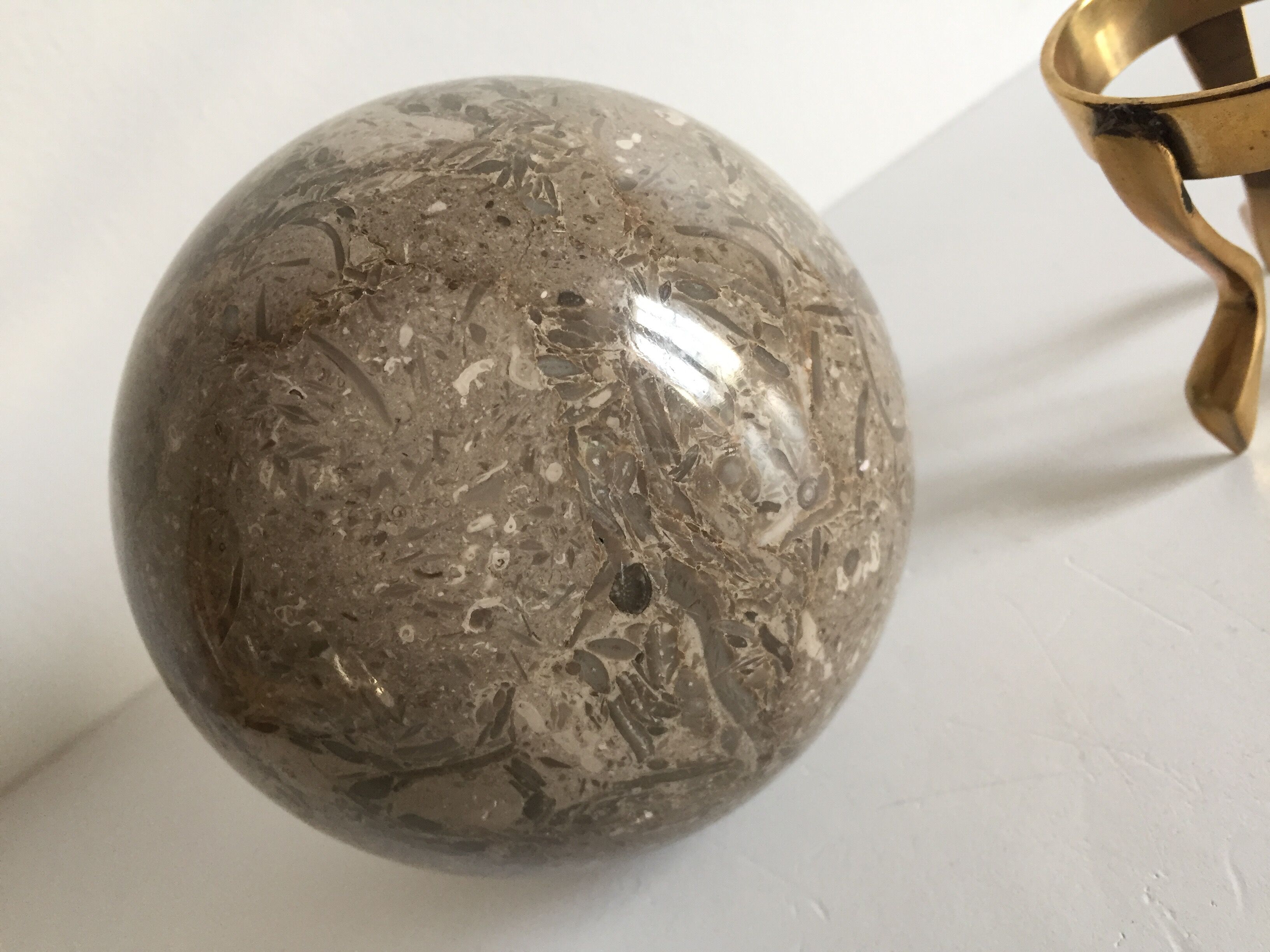 Marble ball paperweight on vintage brass
