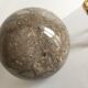 Marble ball paperweight on vintage brass