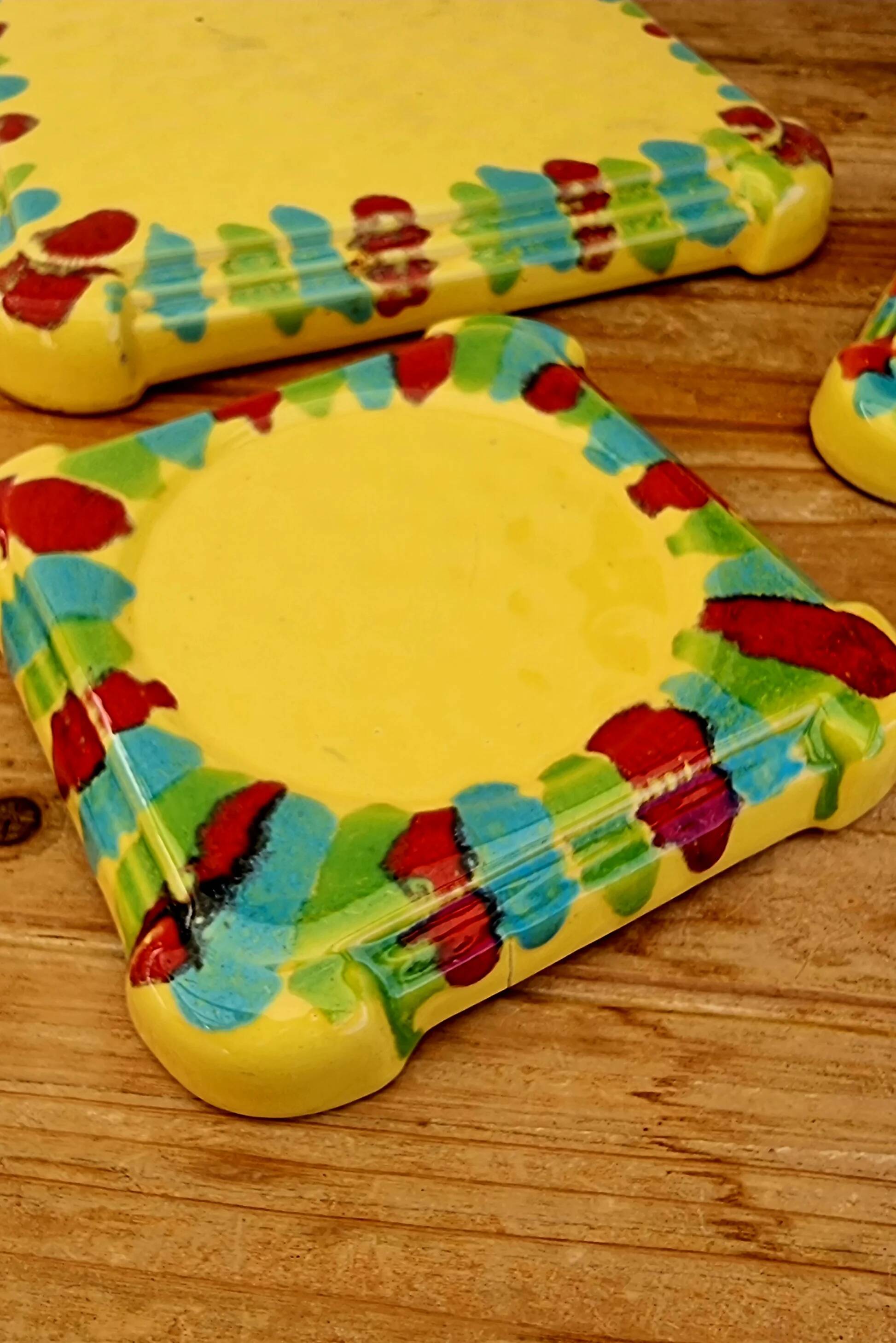Yellow ceramic trivet and bottle coaster with vintage painted decoration.