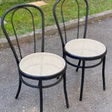Pair of black steel and plastic cane bistro chairs