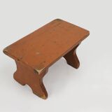 French rustic low church stool in terracotta painted wood, ca. 1900