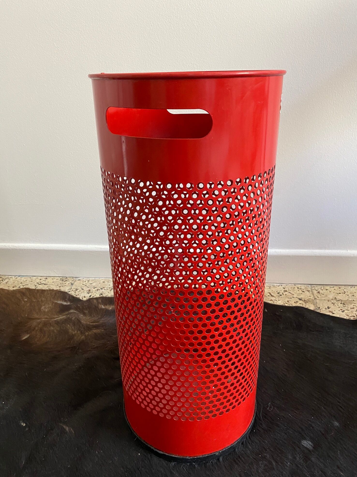 Vintage red umbrella holder in 80s perforated sheet metal or Italy trash can