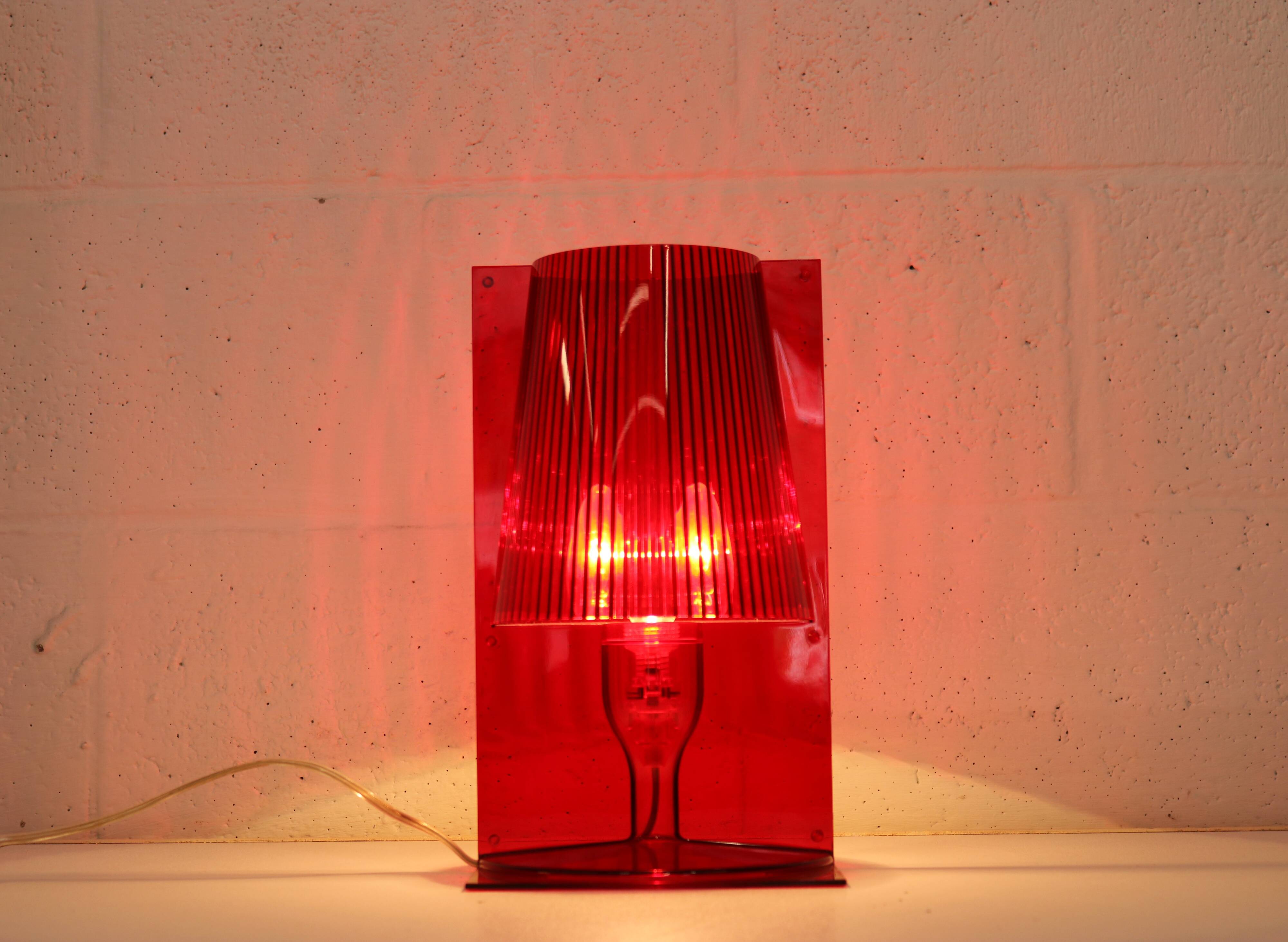 Red plastic Kartell table lamp - model Take - design by Ferruccio Laviani