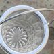 Whiskey carafe and ice bucket in transparent glass and silver-colored metal handle