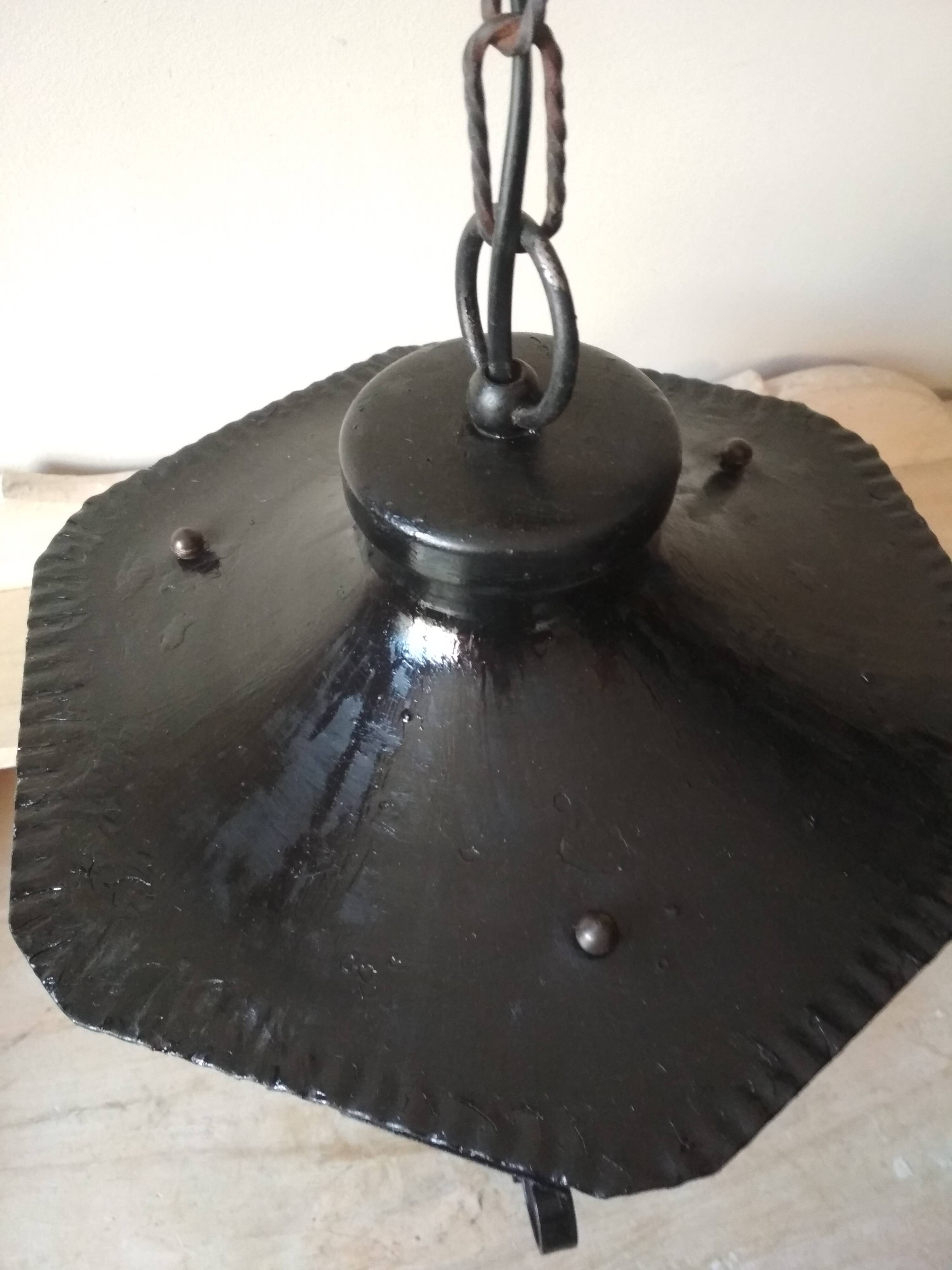 Large hanging lantern in wrought iron and opaque yellow-orange windows