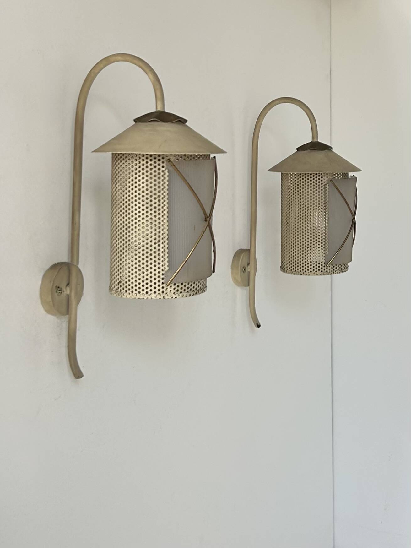Pair of vintage wall lights in perforated metal, brass, and perspex, France, 1950.