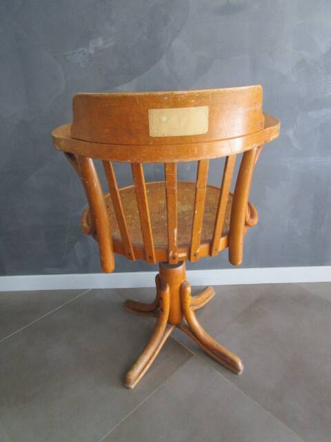 Old swivel office armchair in curved wood