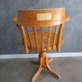 Old swivel office armchair in curved wood