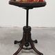 Antique curved wooden piano stool with kilim fabric from the 1910s.