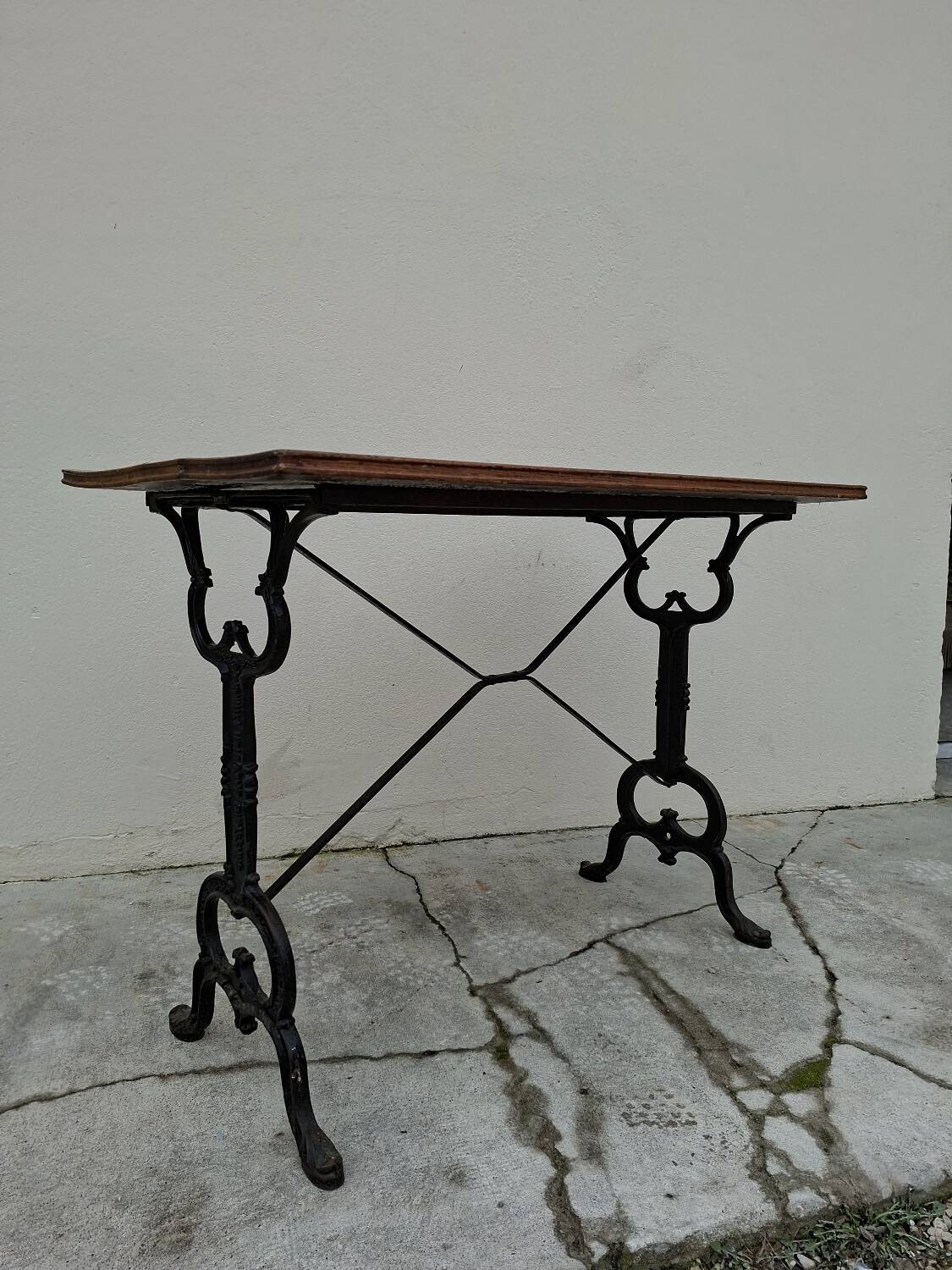 Solid oak bistro table with a cast iron base, signed.