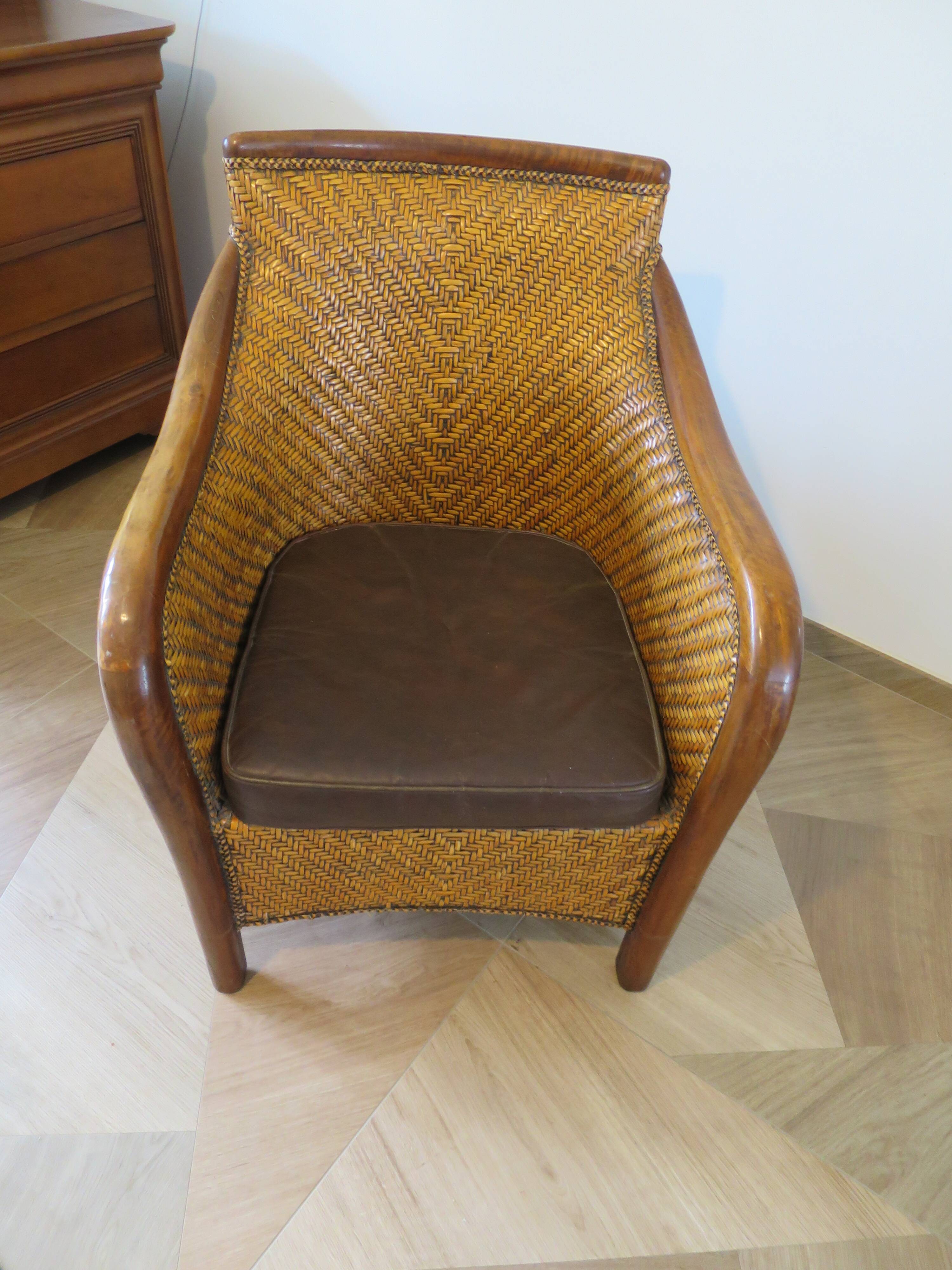 Colonial style armchair in woven rattan and exotic wood