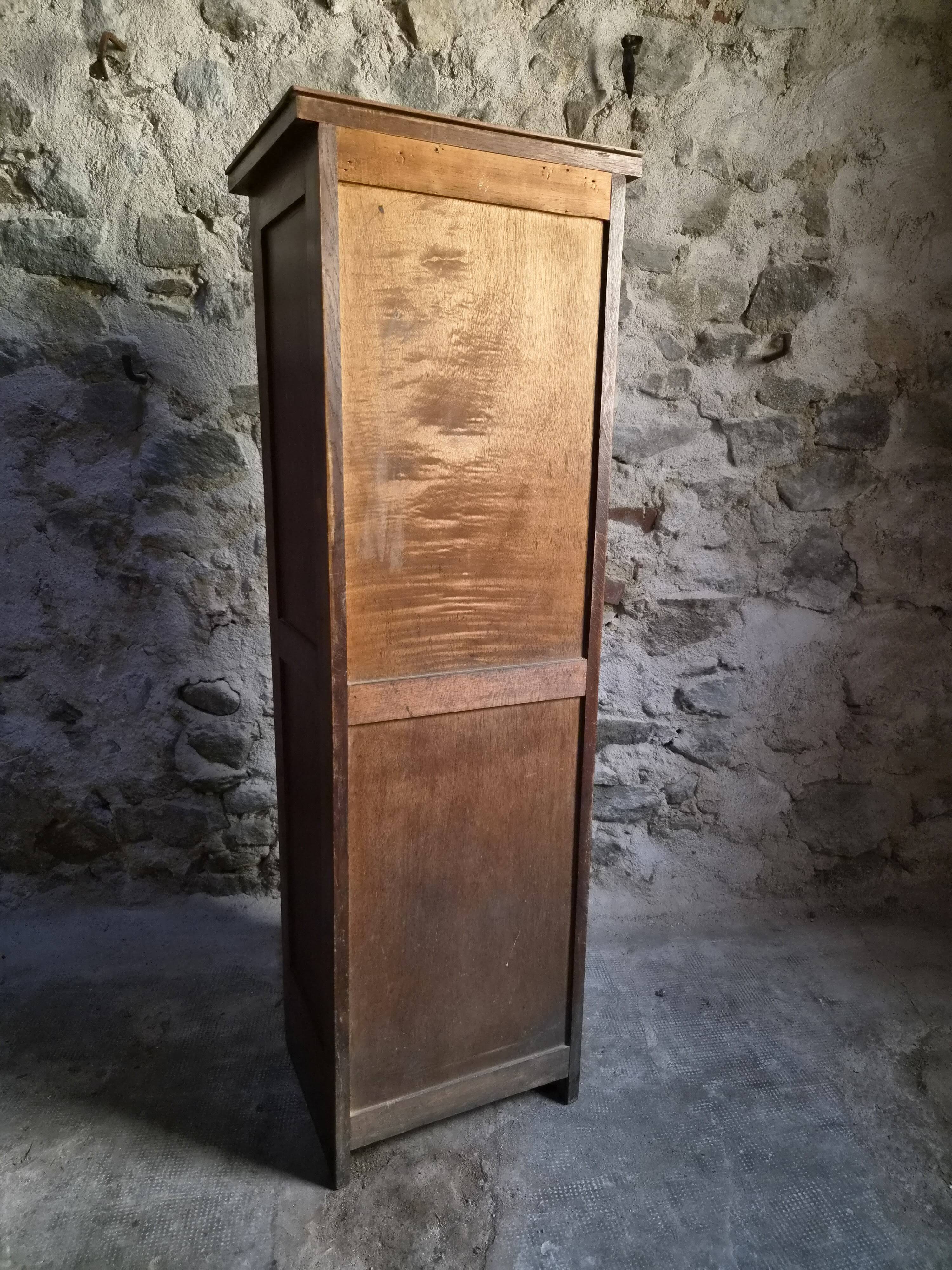 French antique wardrobe with curtain in oak, circa 1920–1930.