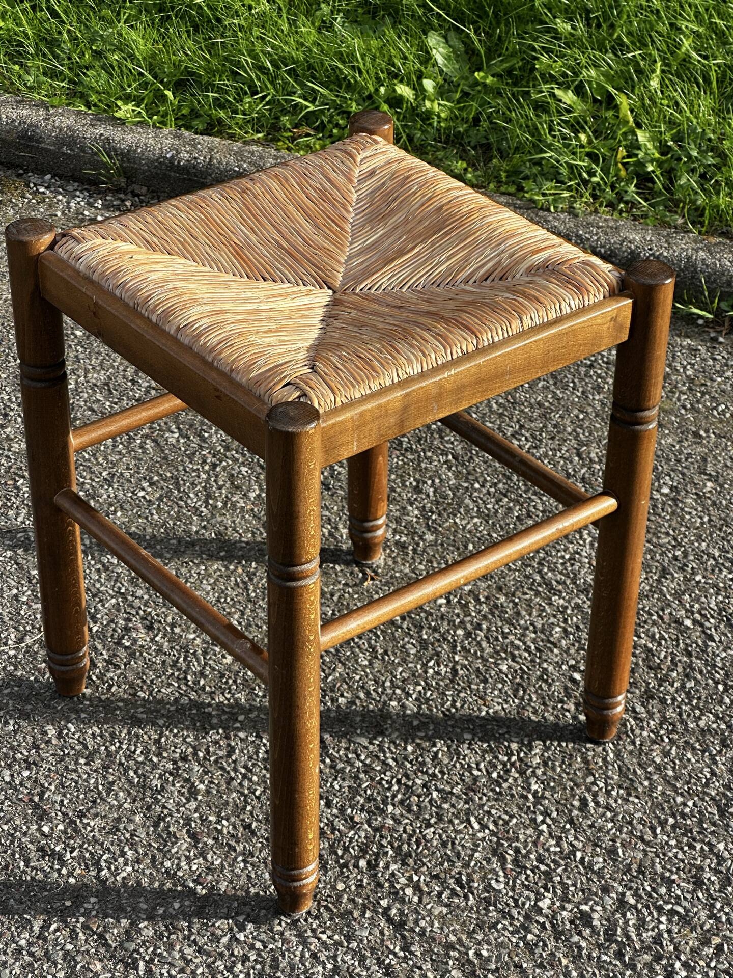 1950s turned wooden stool with a straw seat.