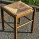 1950s turned wooden stool with a straw seat.