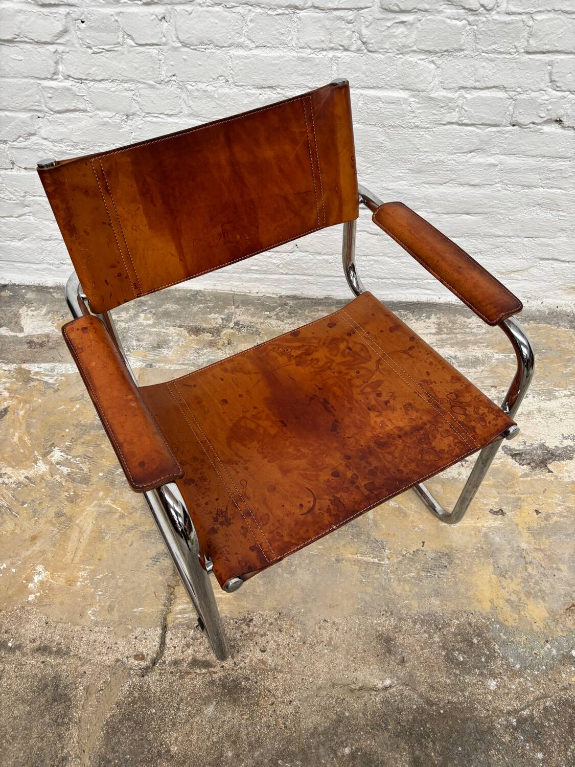 Vintage aluminum tube and tan leather armchair