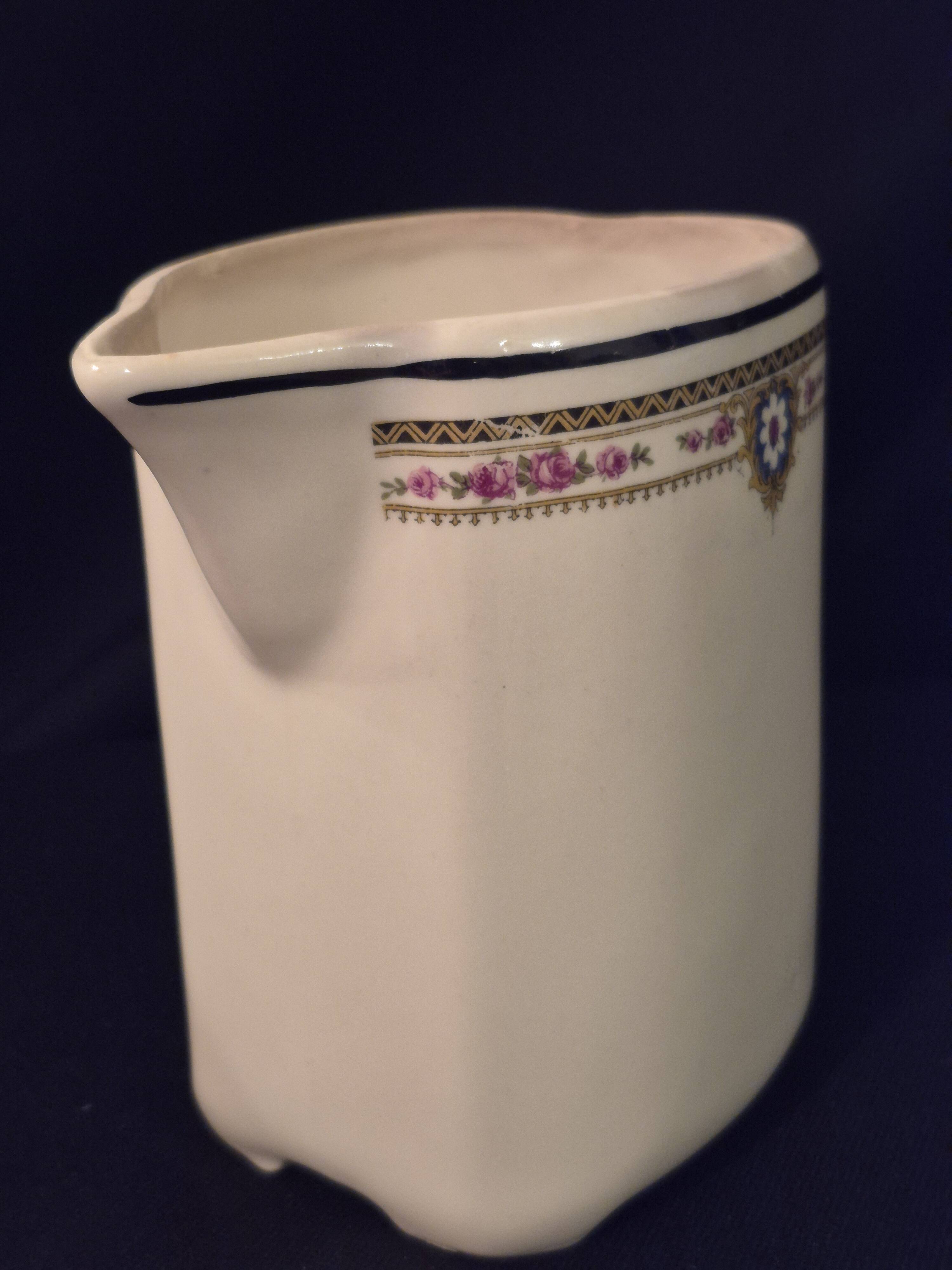 Old covered jug, vintage, geometric frieze with flowers and black trim.