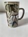 Glazed stoneware mug with free decoration, vintage pottery work.