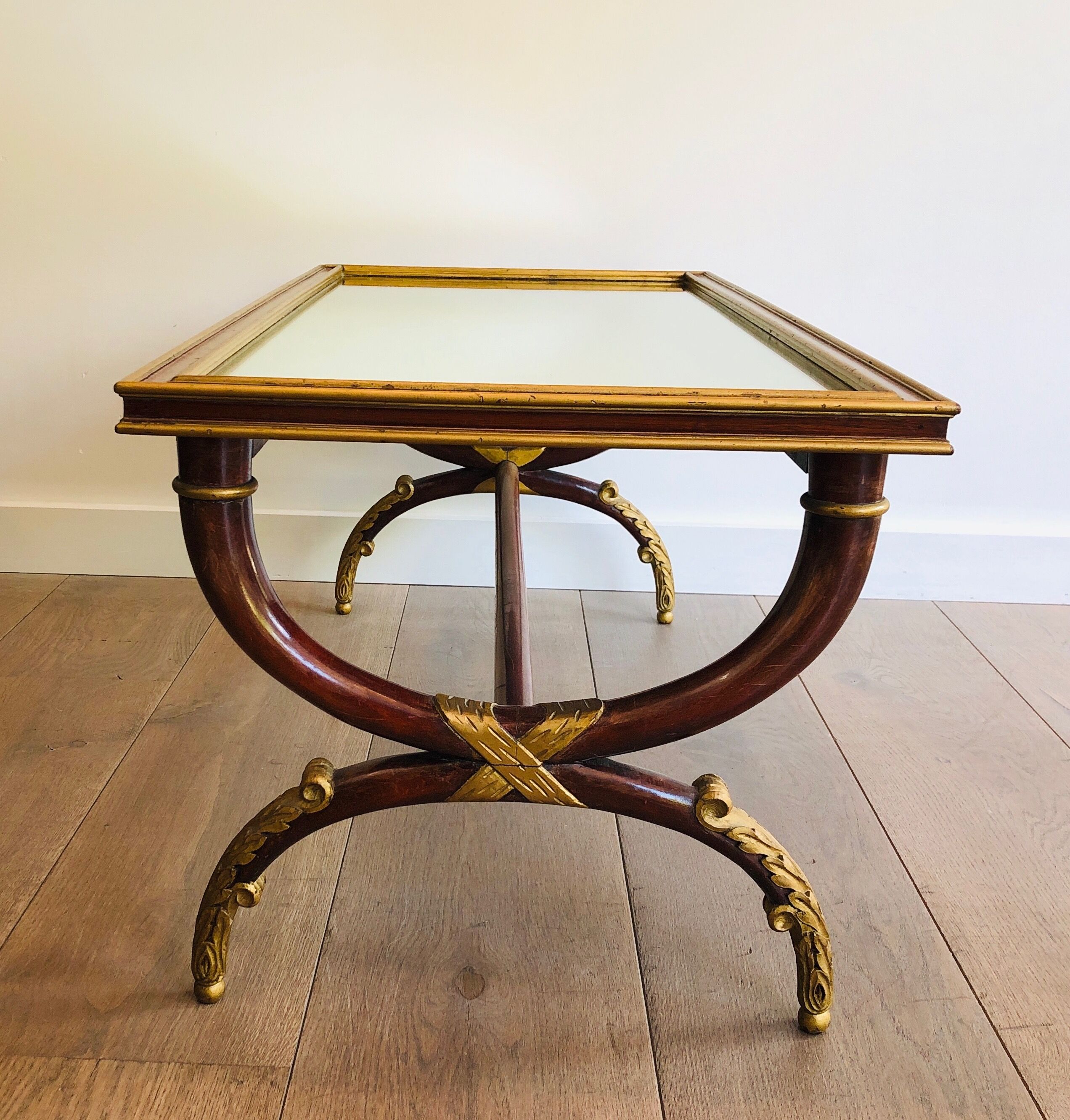 Coffee table in patinated and gilded carved wood with mirror top