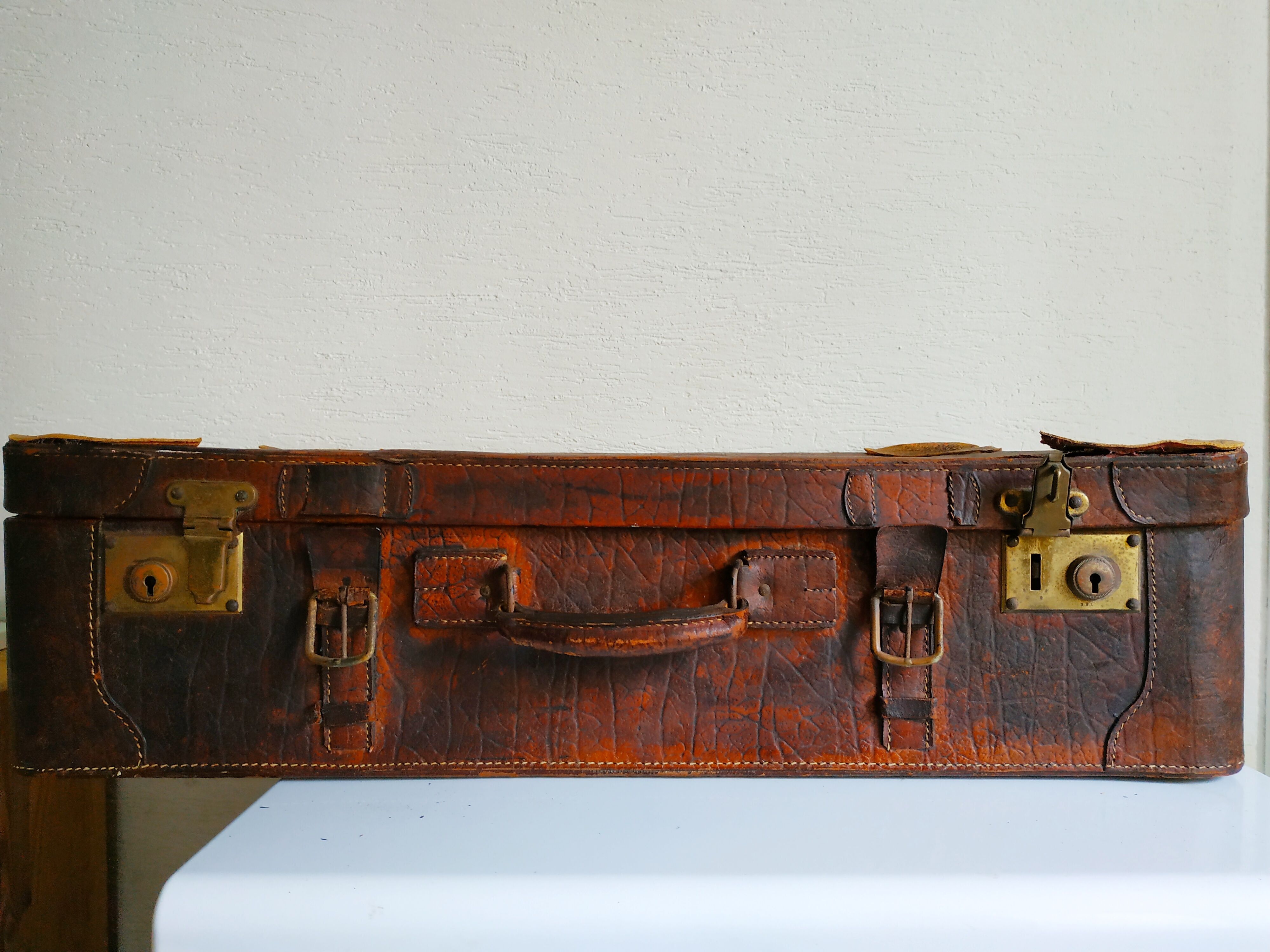 Old cardboard suitcase covered with patinated leather