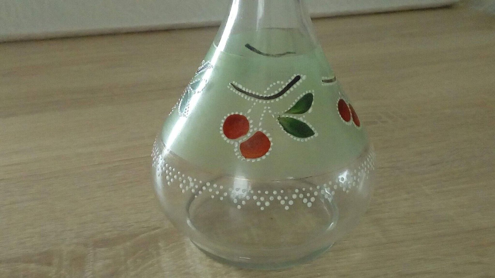 Glass carafe with enamel decoration of cherries.
