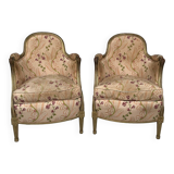Paire de bergères en bois doré garnies de soie à motifs de fleurs, art déco d’inspiration Louis XVI