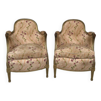 Paire de bergères en bois doré garnies de soie à motifs de fleurs, art déco d’inspiration Louis XVI