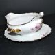 Vintage pouring sauce boat in floral porcelain with gilding.