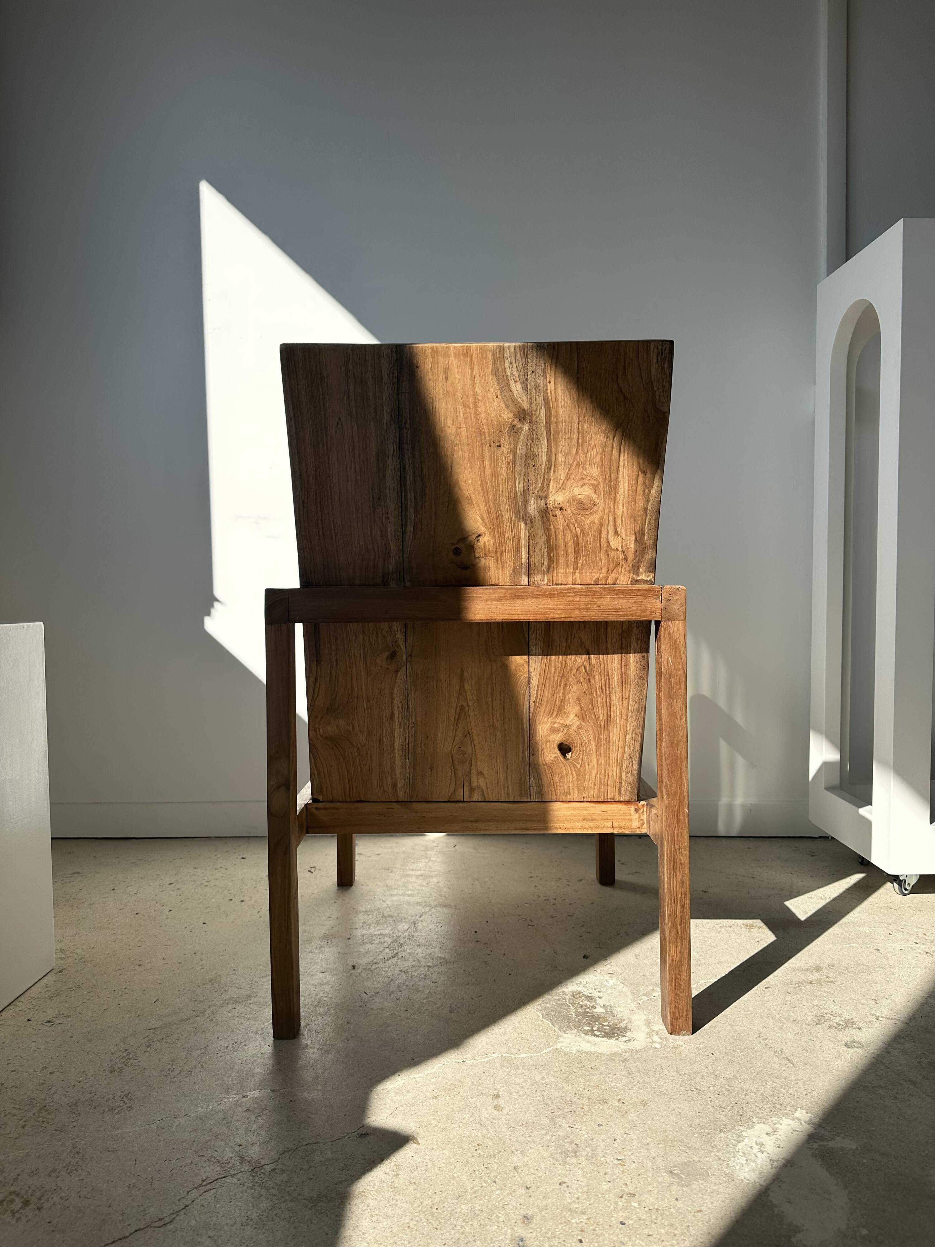 Large armchair in natural wood (teak) with a minimalist design.