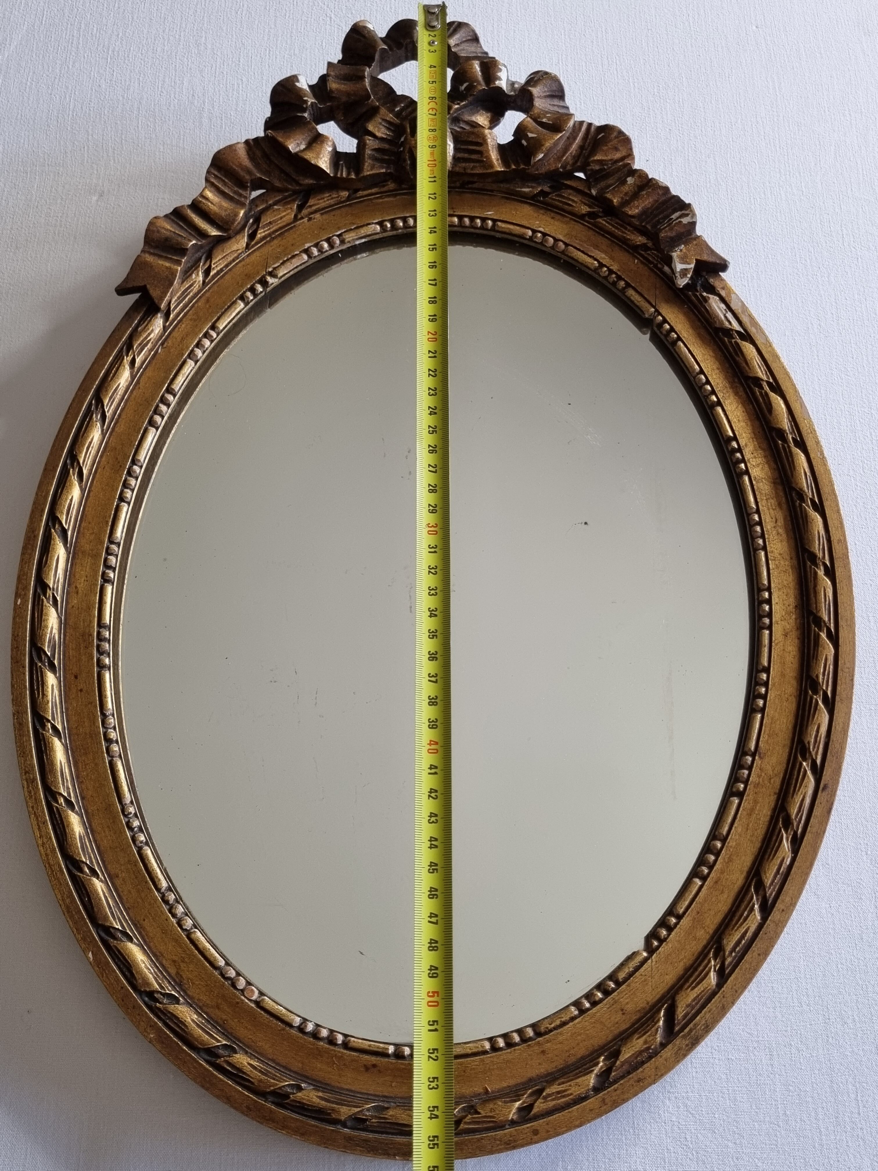 Louis xvi style oval mirror decorated with ribbons