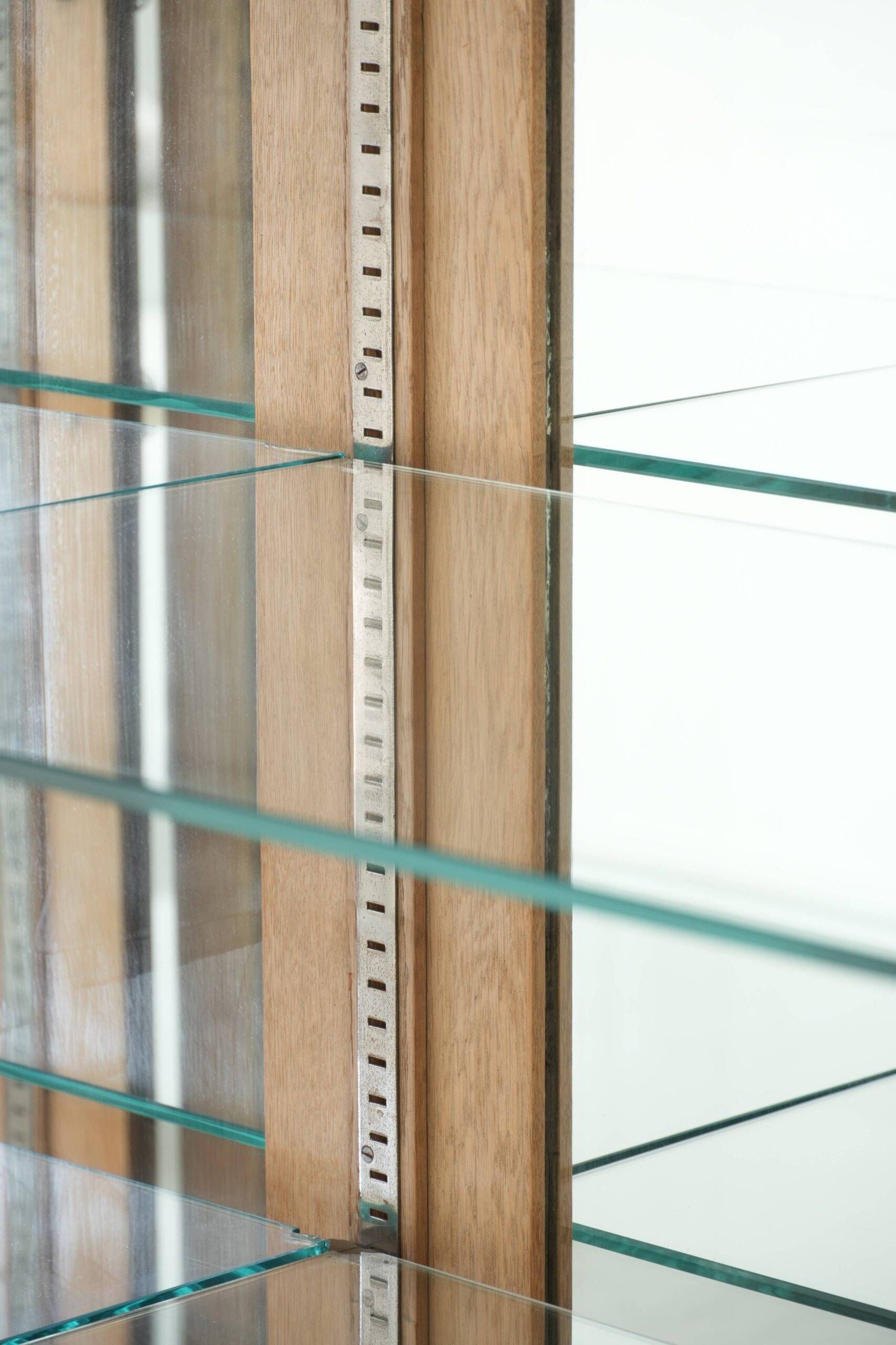 Antique Dutch oak display cabinet with glass shelves and a mirrored back