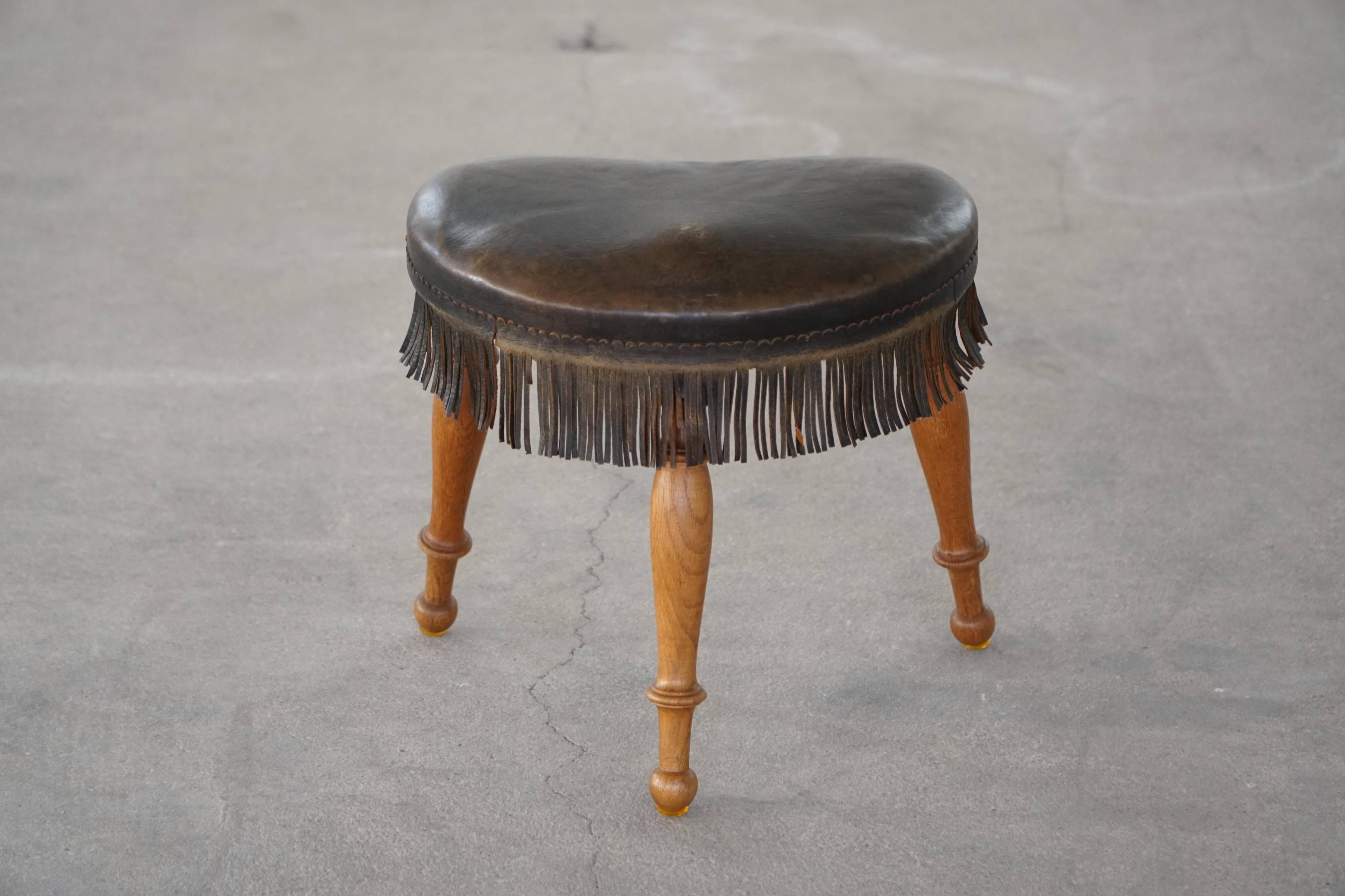 Danish oak tripod stool from the early 20th century with leather fringe, 1930s.