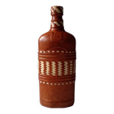 Vintage glass bottle covered with light brown leather and wicker