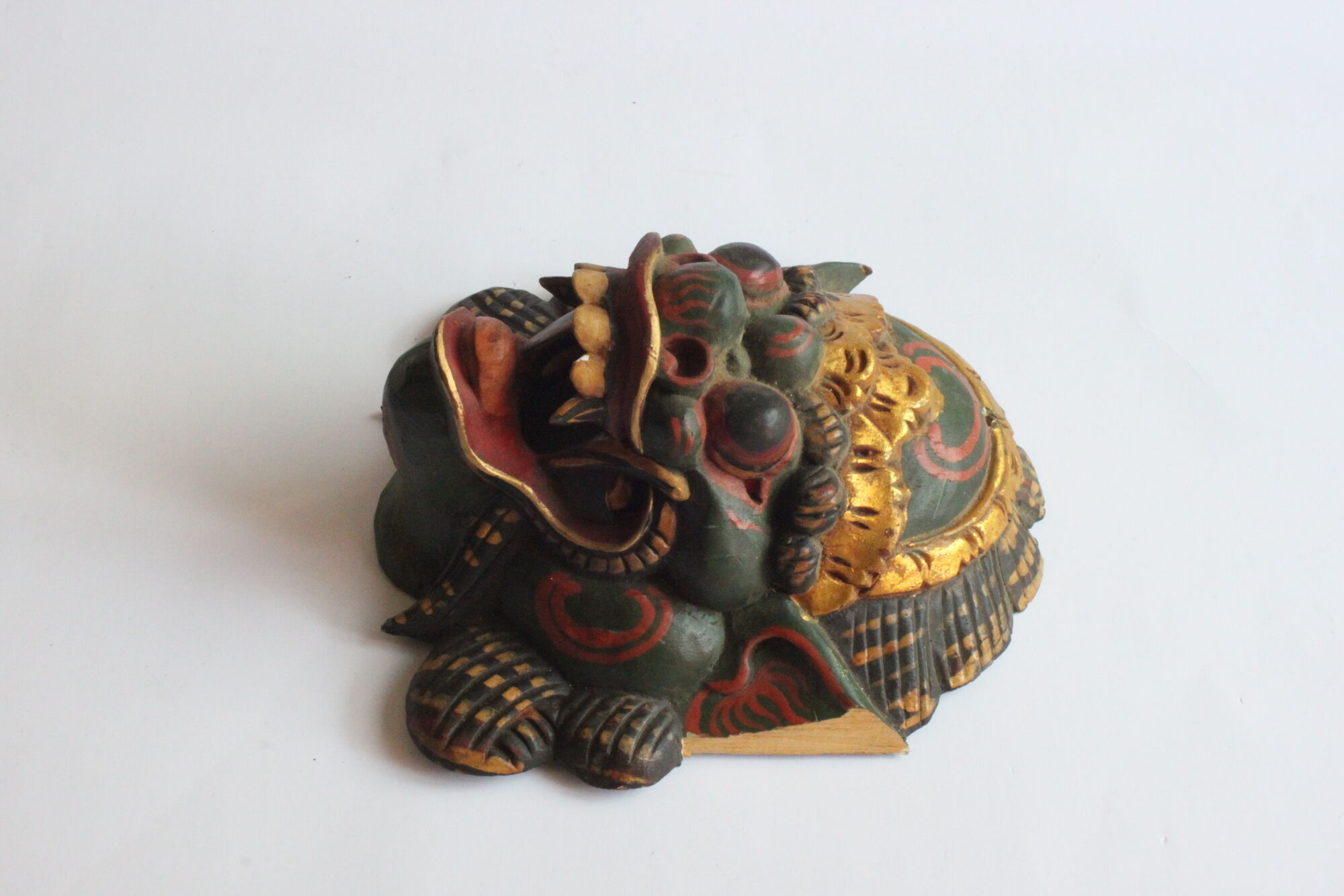Two polychrome painted and gold leaf gilded Barong dance masks from Bali, Indonesia.