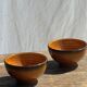 Pair of small orange bowls with black edging