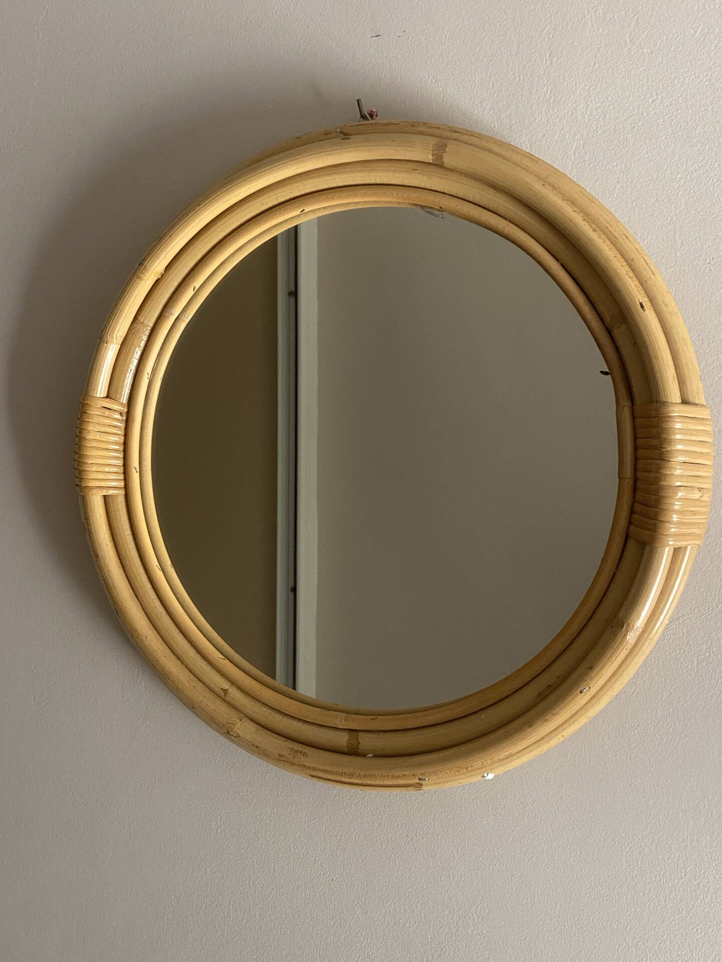 Round mirror from the 1960s with a frame made of rattan and metal.