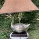 Old vintage lamp representing a duck in silver metal with wooden base