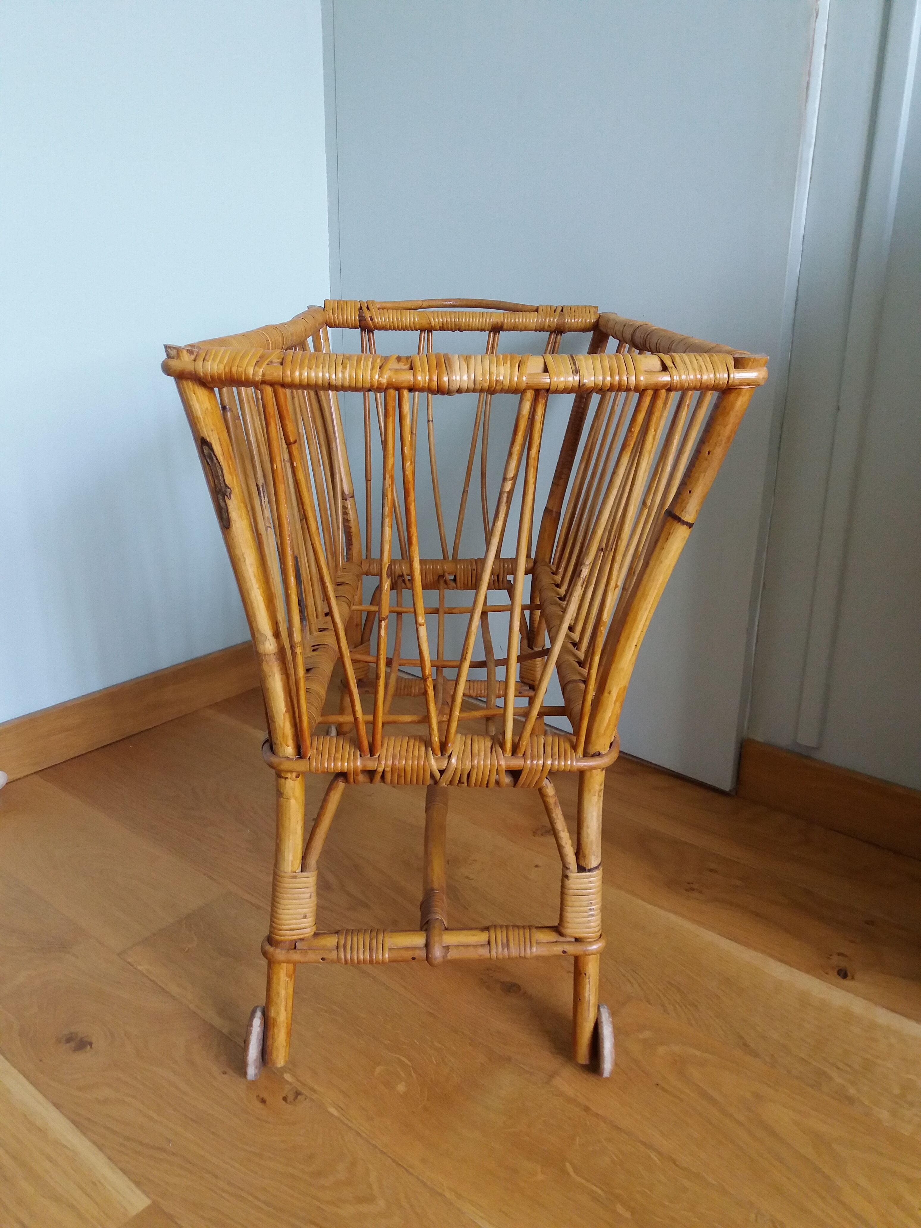 Rattan wicker cradle on wooden wheels