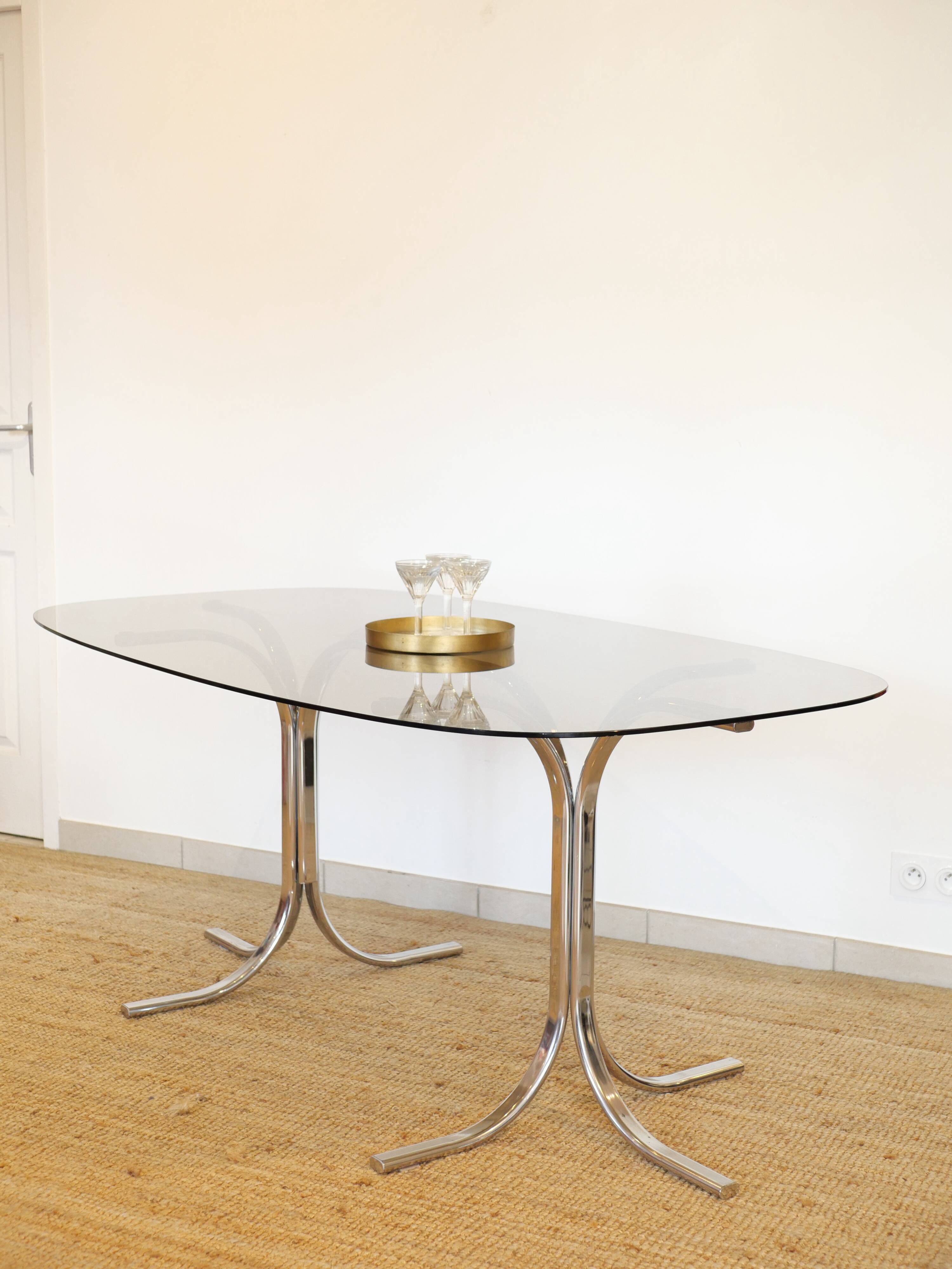 Dining table with smoked glass top and chrome base.