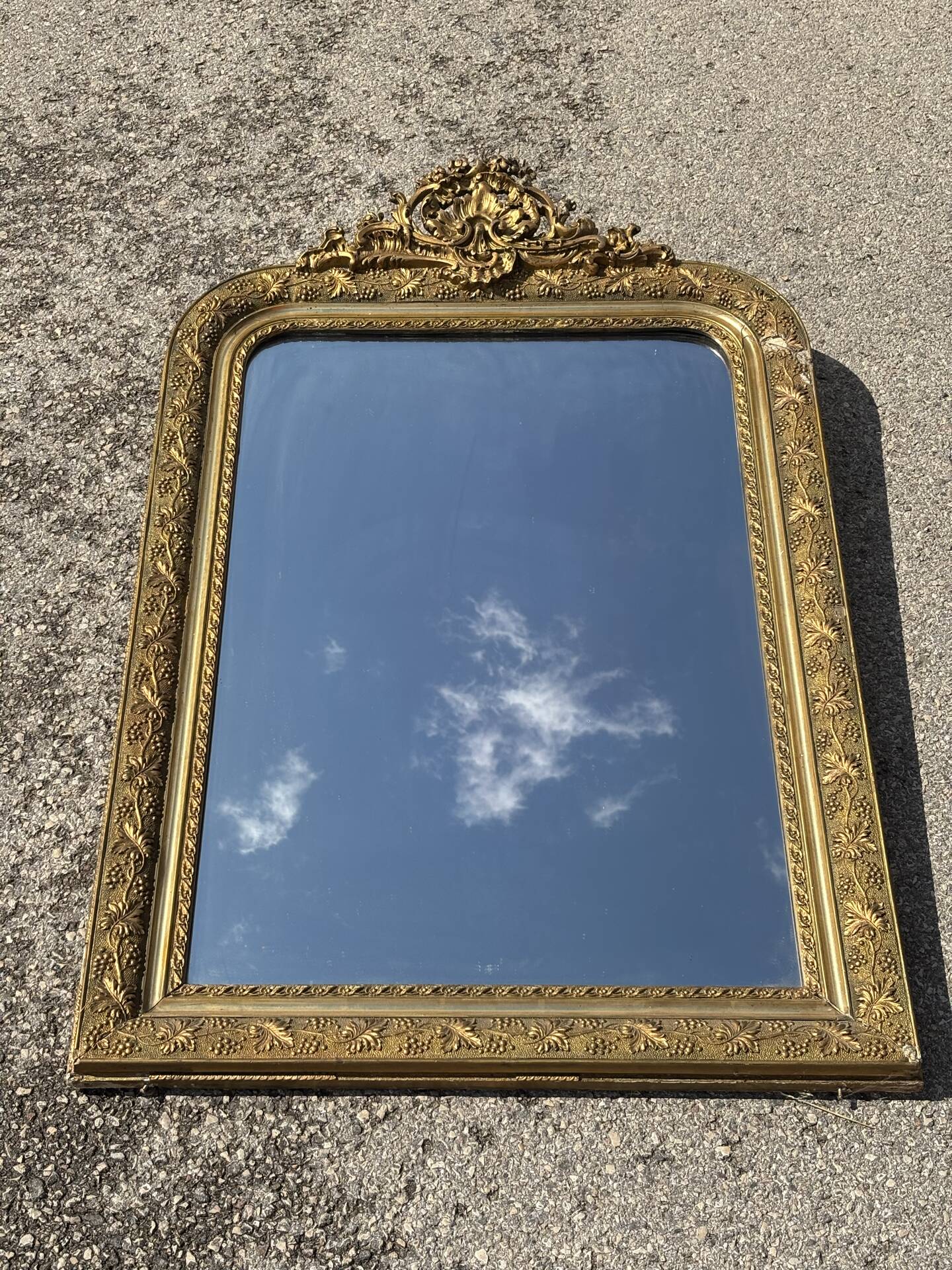 Golden mirror with a pediment from the early 20th century.