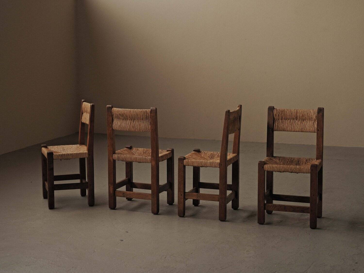 Set of four modernist chairs in oak and straw, France, circa 1960.