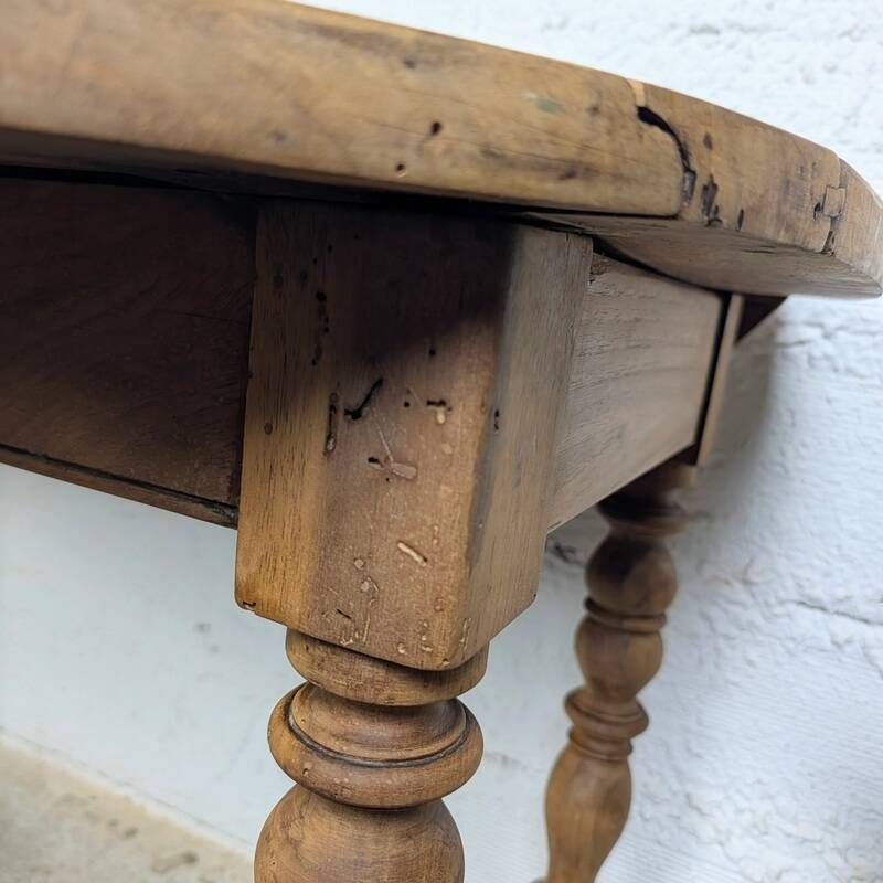Antique wooden drop-leaf table with turned legs.
