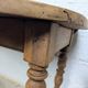 Antique wooden drop-leaf table with turned legs.