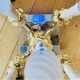 Massive gilded bronze chandeliers from the mid-20th century with marble bases.