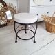 Black iron stool/pouf with its boucle fabric cushion.