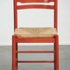 Red vintage wooden chair from the 1970s with a woven wicker seat