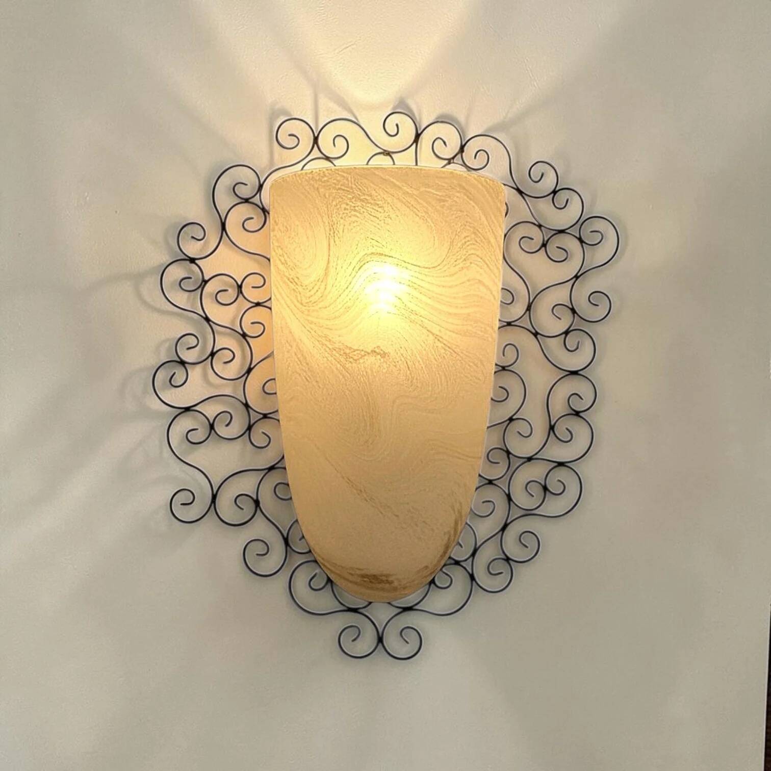 Wrought iron pocket wall sconces featuring a frosted amber glass / metal frame