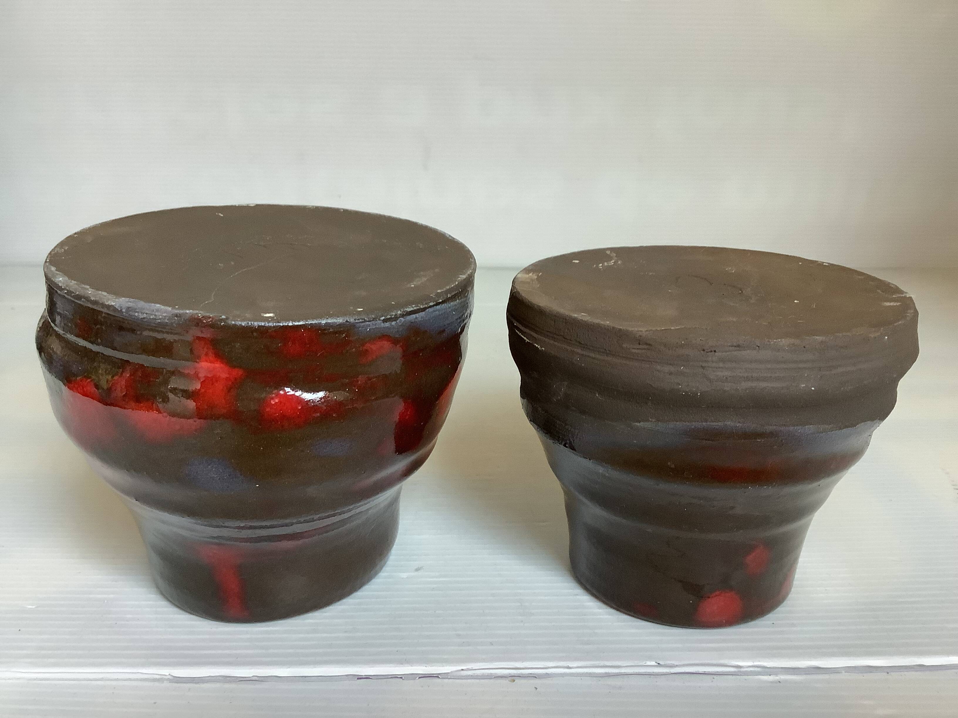 Pair of red vases in the shape of an elephant's foot