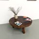 Brutalist coffee table in solid teak, monolithic slab, tripod base.